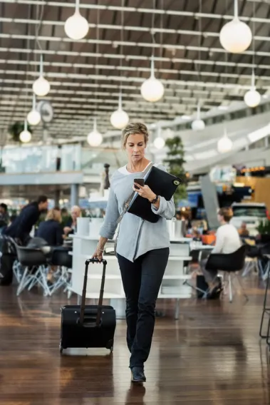 Business woman using phone at airport