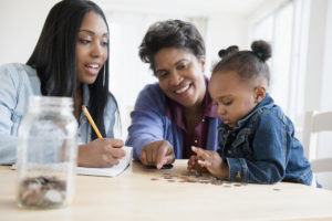 Mother, daughter and grandmother counting coins