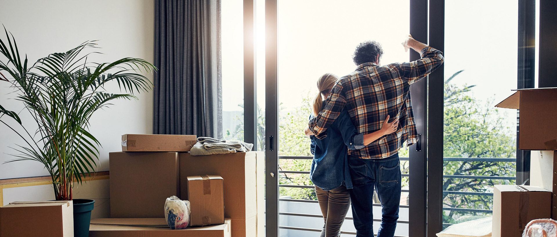 Man and woman embracing in a home with moving boxes