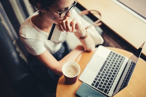 Woman making credit card purchase on laptop
